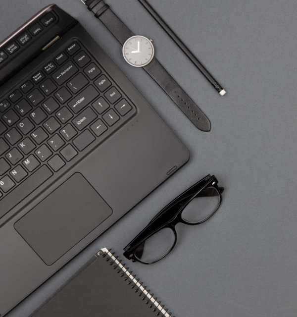 workplace of businessman - laptop, glasses and notepad, flat top view